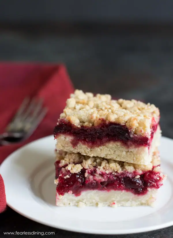 Two gluten free cranberry shortbread cookie bars stacked on a plate