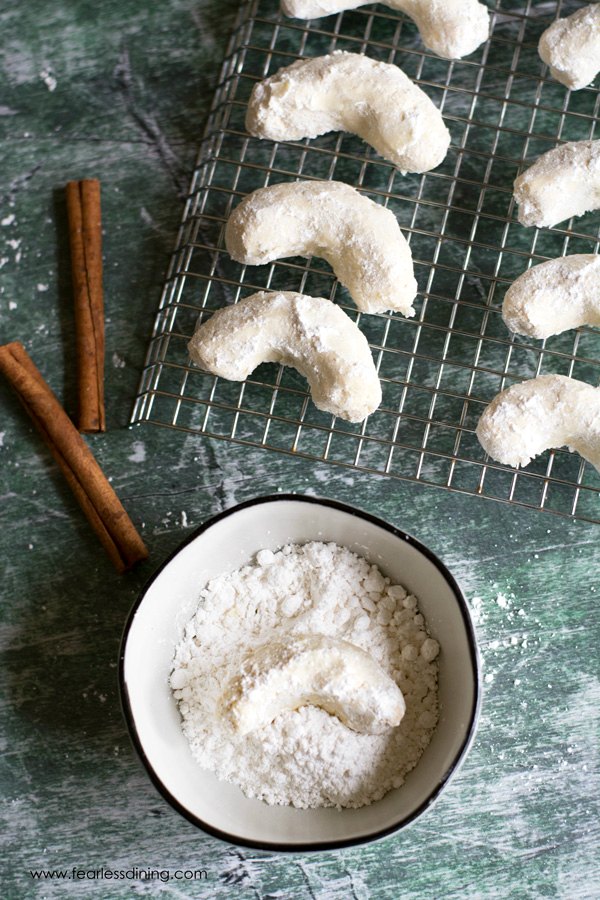 Rolling the cookies in powdered sugar.