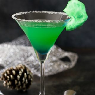 A grinch cocktail in a martini glass.
