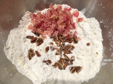 Dry ingredients with bacon and pecans in a bowl