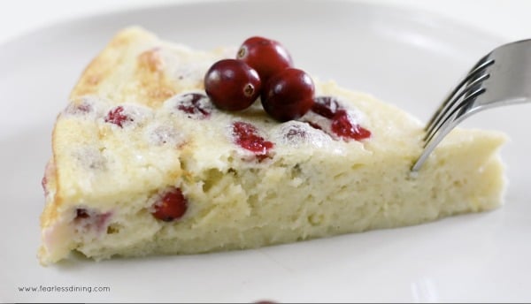 A fork cutting into a piece of cranberry yogurt cake.