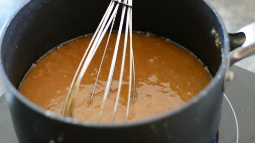 A pot of cooking toffee where the butter separated out. It looks oily.