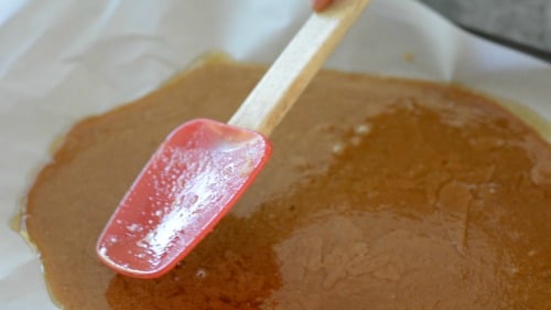 Spreading toffee out on parchment paper after the butter separated out. 