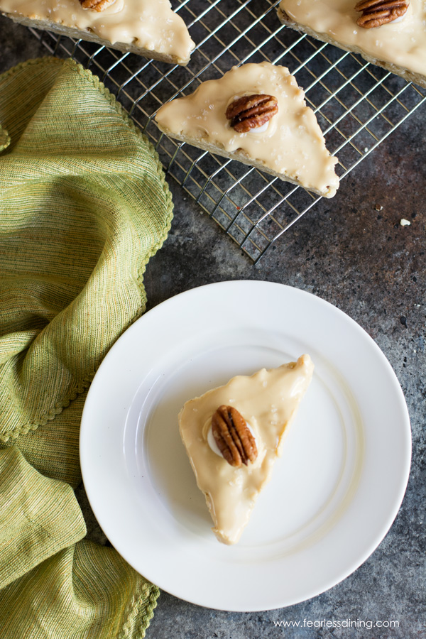 Top view of a gluten free maple bacon scone on a plate. A light green napkin is next to the plate.