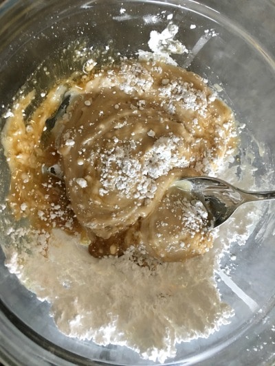 A spoon is mixing the maple glaze.
