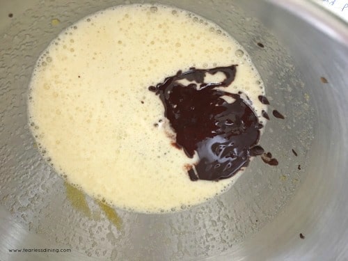 Adding melted chocolate to egg and sugar mixture.