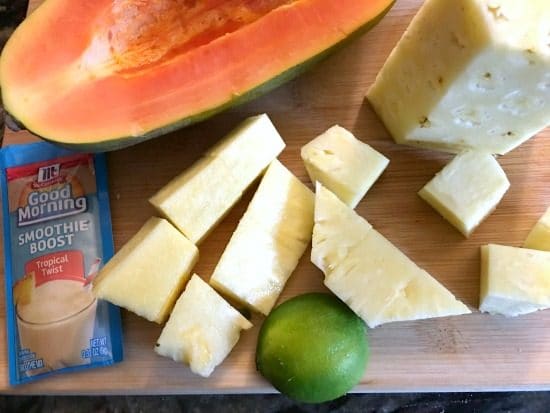 papaya lime and pineapple on a cutting board