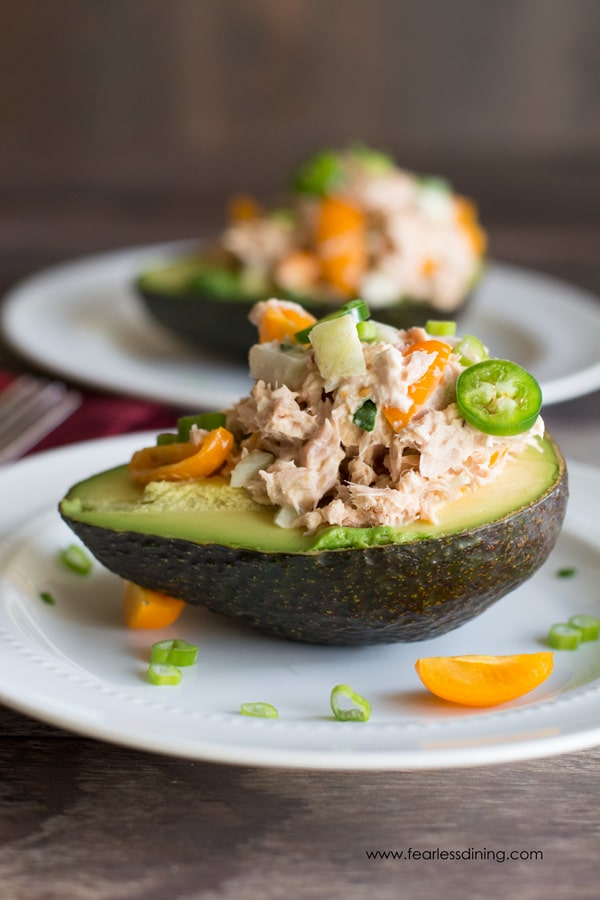 Half of an avocado stuffed with tuna salad, bok choy, and cherry tomatoes.