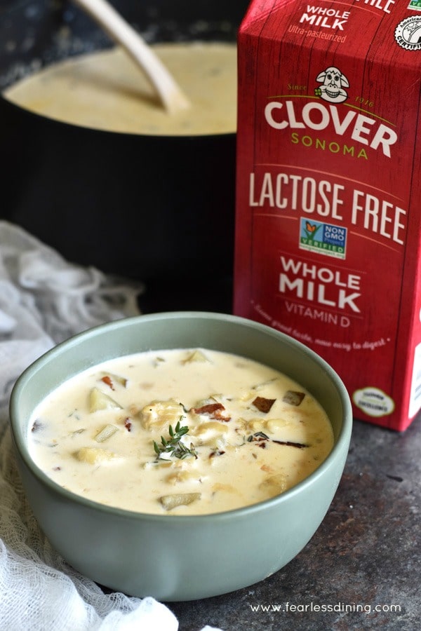A bowl of chowder next to Clover lactose free milk.