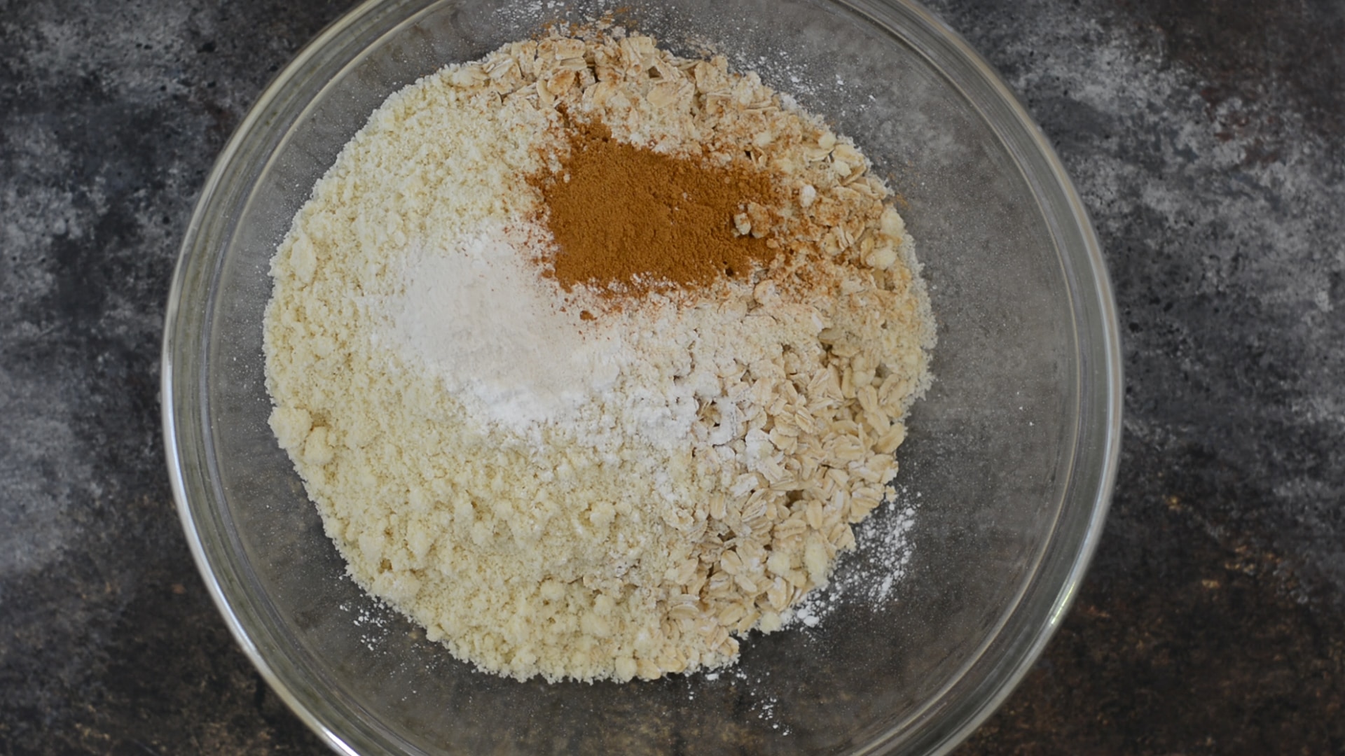 The oatmeal muffins dry ingredients in a glass mixing bowl.