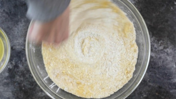 Using a whisk to blend the dry ingredients in a large glass bowl.