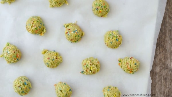 funfetti cookie dough balls on a baking sheet.