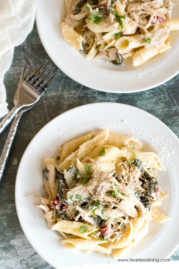 Top view of two plates of gluten free Tuscan chicken pasta