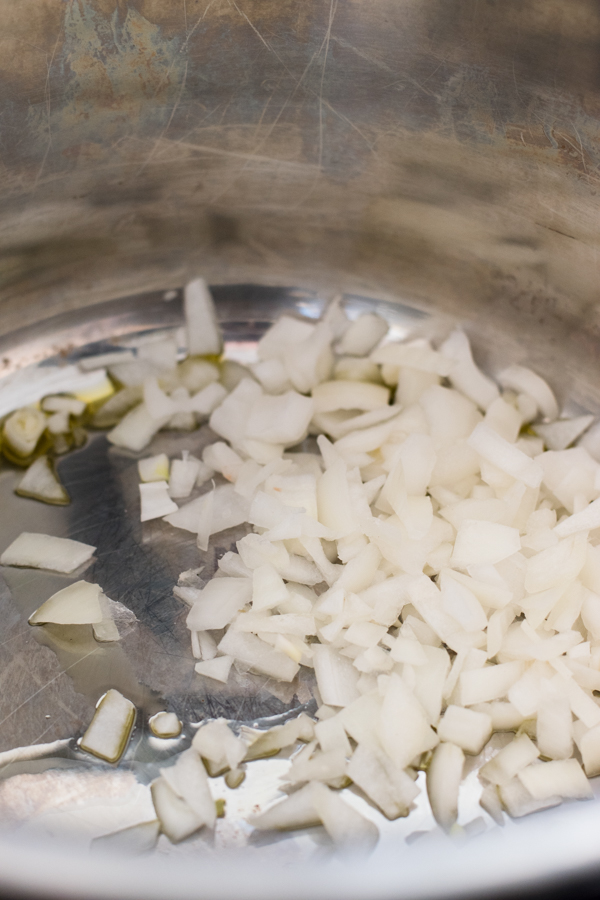 The onions cooking in a pot with oil.