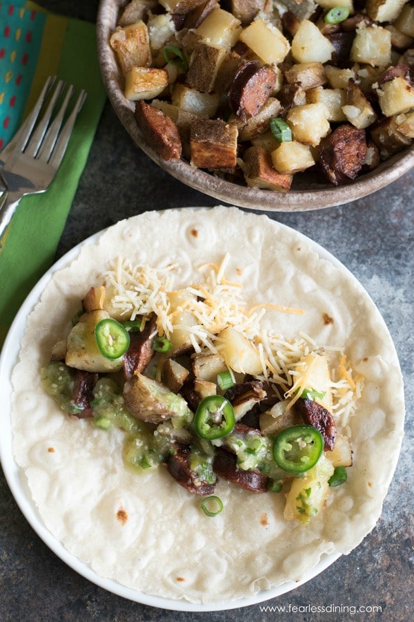 Potatoes, chorizo, salsa and cheese on a flour tortilla