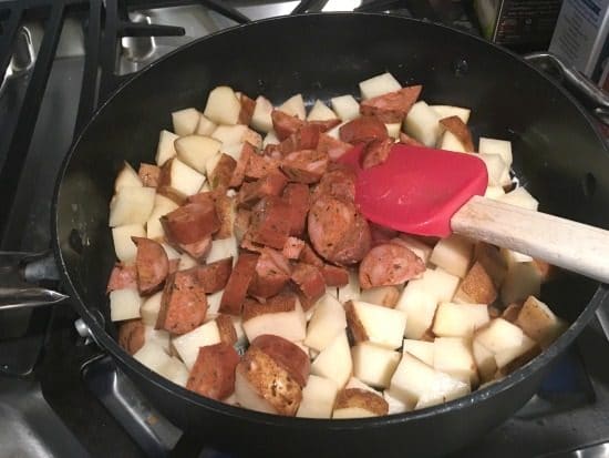 potatoes and chorizo cooking in a cast iron skillet