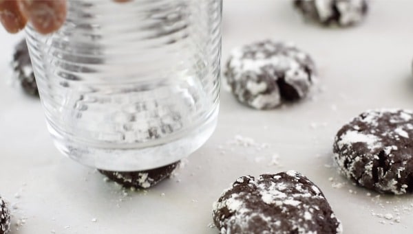 Using a glass to smoosh the cookies flat.