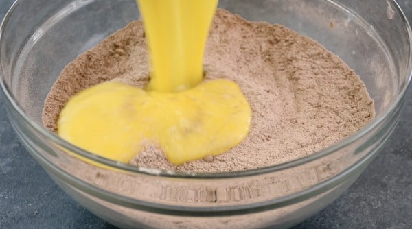 Pouring the wet ingredients into the dry ingredients.