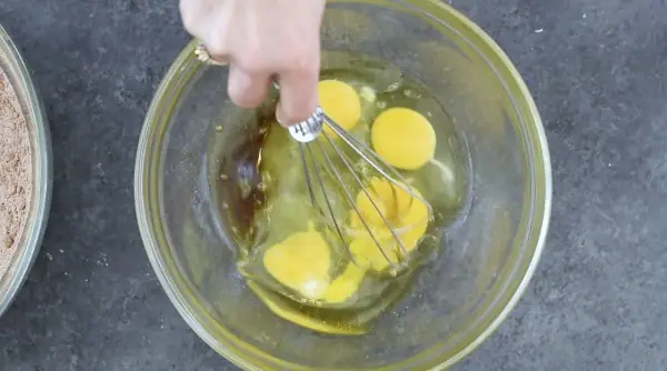 whisking wet ingredients in a glass bowl