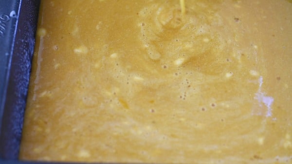 Pouring the lemon mixture over the crust in the pan.