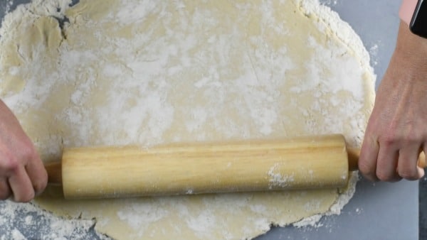 a rolling pin is rolling out the dough
