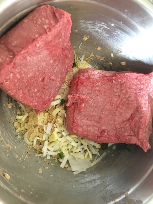Ground beef added to meatloaf ingredients.