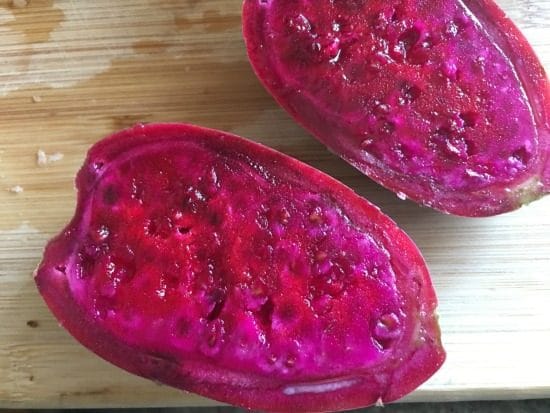 A prickly pear cut open so you can see the magenta color inside.