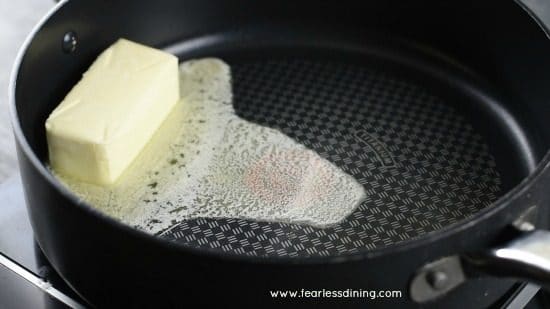 Butter melting in a large skillet.