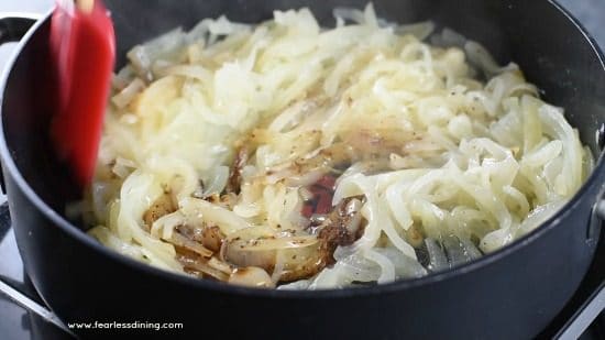 Stirring the cooking onions as they caramelize.