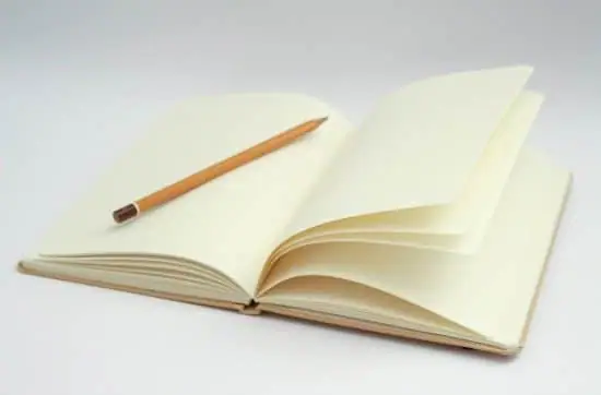 an open blank notebook with a pencil on a page