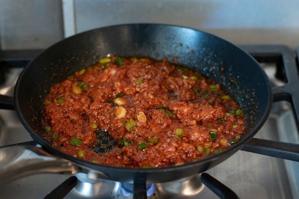 The chorizo cooking in a skillet over low heat.