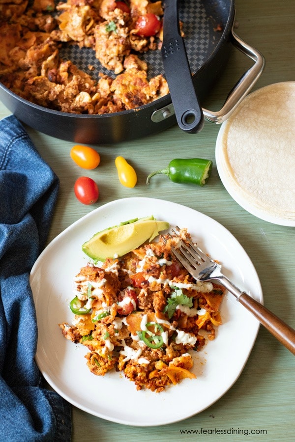 The top view of a plate of migas with the pan behind the plate.