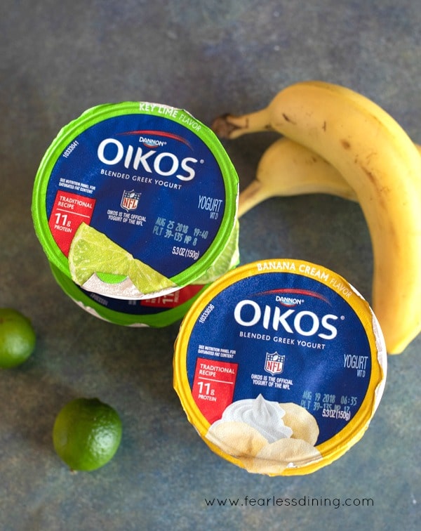 Key lime and banana cream Oikos Greek Yogurt containers with bananas.