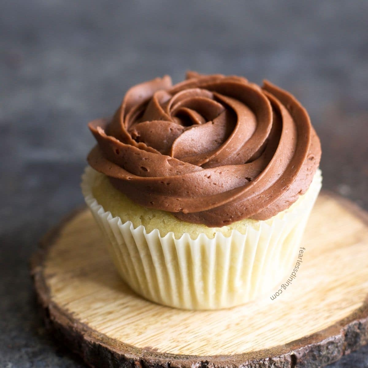 A gluten-free vanilla cupcake decorated with chocolate frosting.