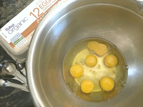 A large mixing bowl with eggs in it.