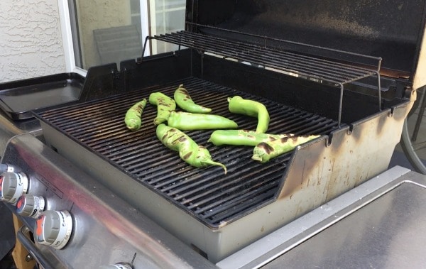 Hatch chiles blistering on a gas grill.