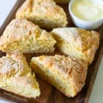 Wedge shaped gluten-free cheese scones on a wooden platter.