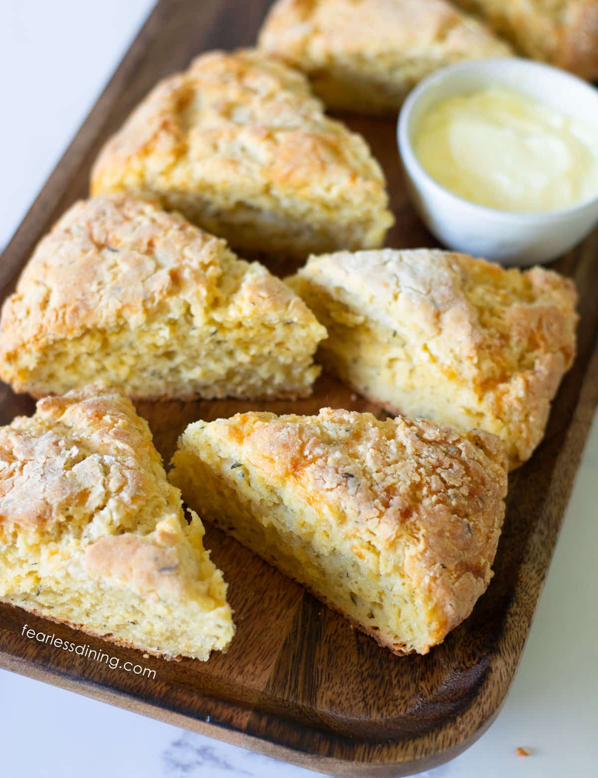Wedge shaped gluten-free cheese scones on a wooden platter.