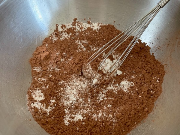 Gluten free chocolate cupcake dry ingredients in a bowl with a whisk.