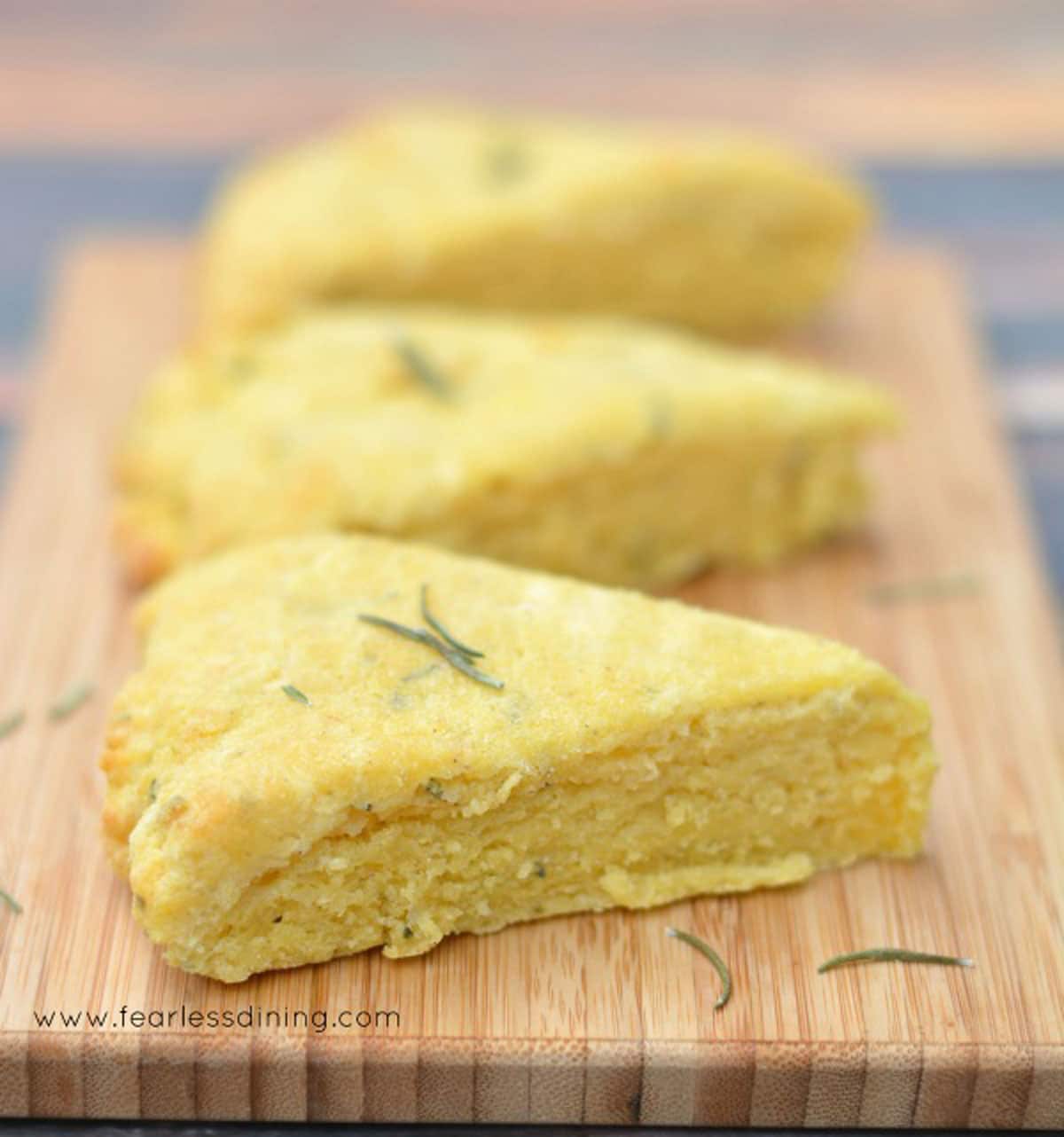 Three gluten free cheese scones on a cutting board.