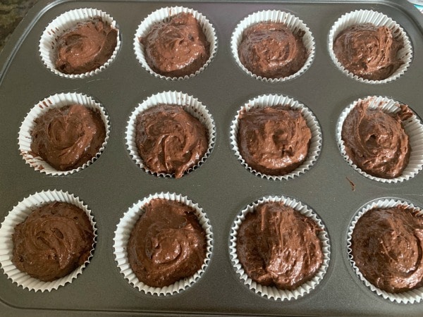 Chocolate cupcake batter in a muffin tin ready to bake.