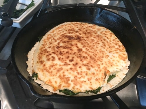Cooking the quesadilla in a cast-iron skillet.