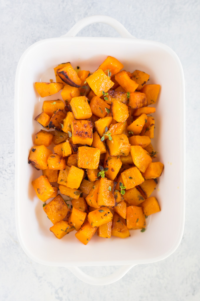 Baked butternut squash in a white serving dish.
