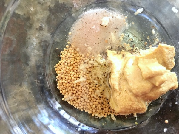 Mustard seeds, mustard, garlic and honey in a bowl.
