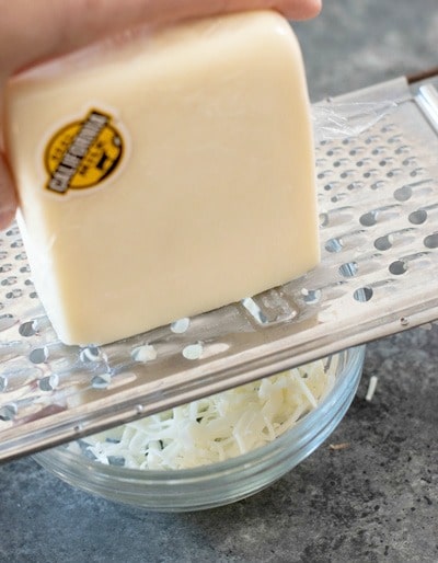 Grating cheese over a bowl.