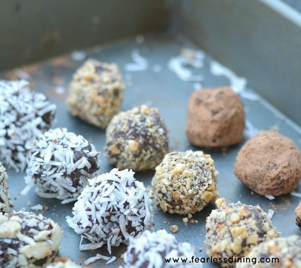 Rows of coated truffles in a pan.