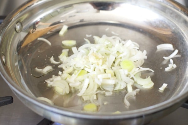 Cooking leeks in a pan with oil and garlic.