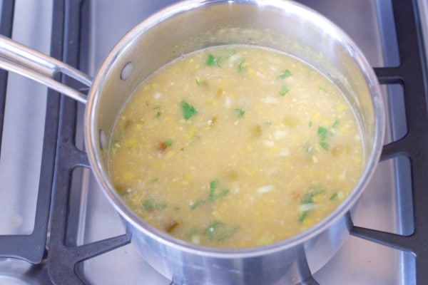 The corn chowder on the stove cooking.