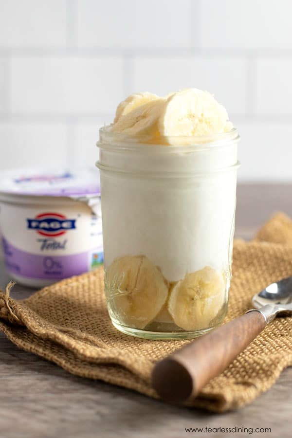 A banana peanut butter yogurt bowl in a mason jar.