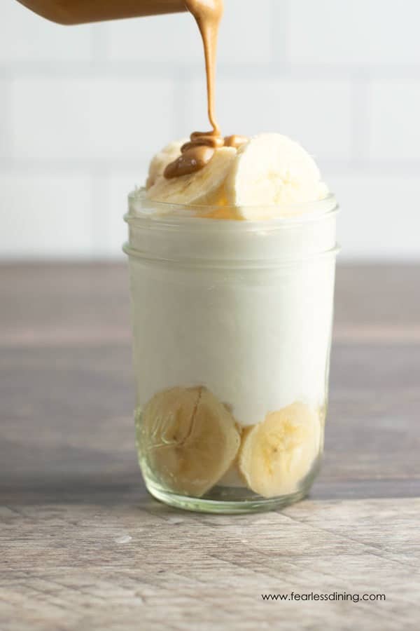 drizzling peanut butter over bananas and yogurt